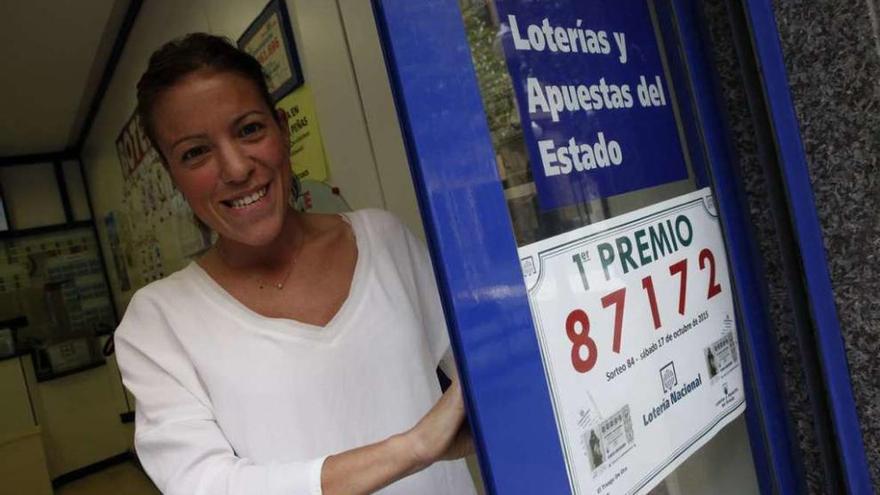 Covadonga Yáñez, junto al cartel que anunciaba ayer el premio de la lotería que repartió.