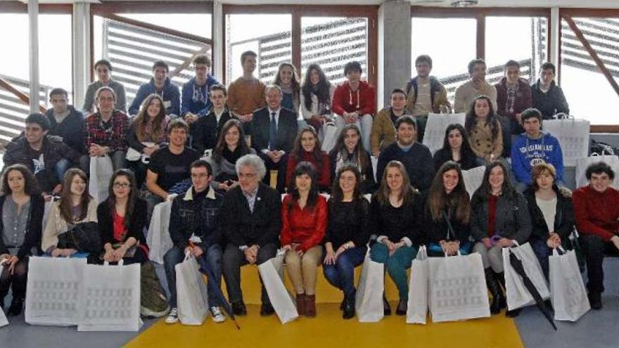 El rector (centro) y el vicerrector (en primera fila), rodeados de los alumnos premiados. // Marta G. Brea