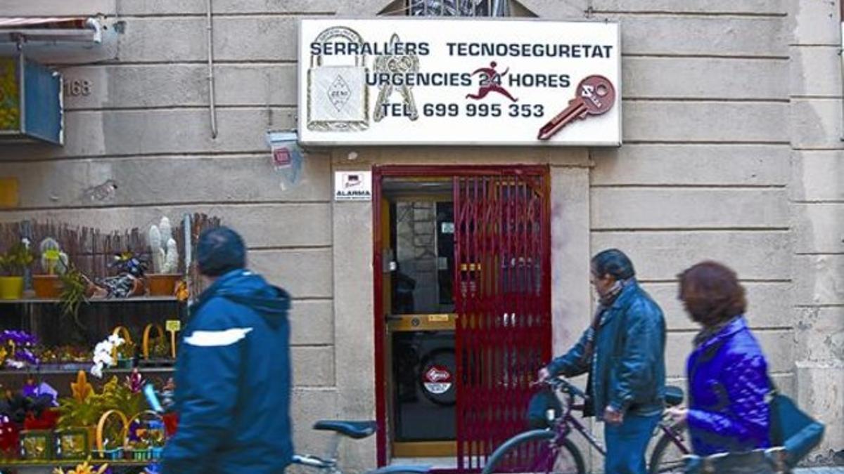 Unos viandantes pasan por delante de la cerrajería de los dos detenidos, ayer.