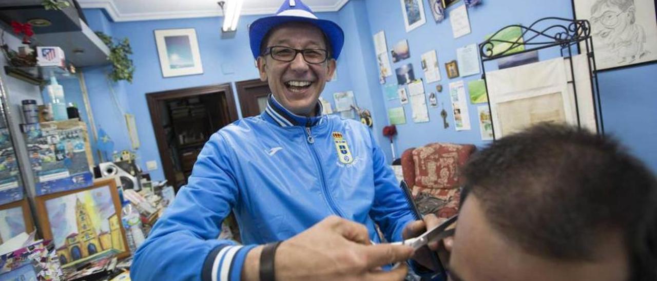 Jacinto Rodríguez, en su peluquería, cortándole el pelo a un cliente.