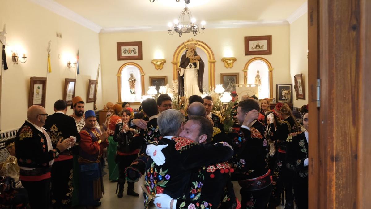 Los porteadores de San Antón, este año los festeros de la comparsa de Contrabandistas, abrazándose tras cumplir el ritual de dejar al patrón en su ermita.