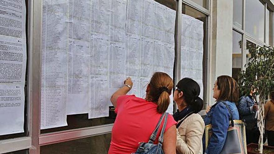 Una imagen de archivo de un grupo de opositorias consultando el listado de los presentados a la OPE.