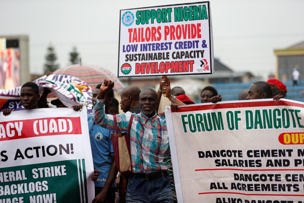 Workers hold signs and shout slogans during a ...