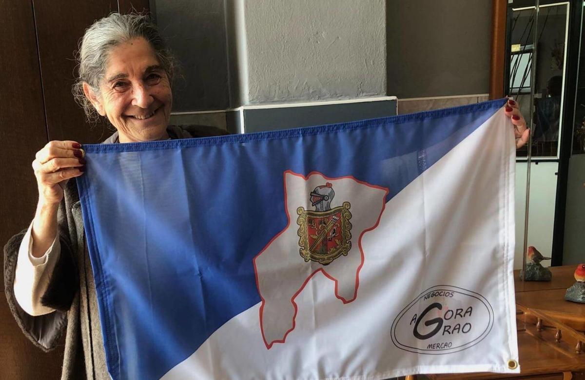 Sagra Fernández, con la bandera del concejo, a la que Agora Grao le ha añadido su logo, visible a la derecha.