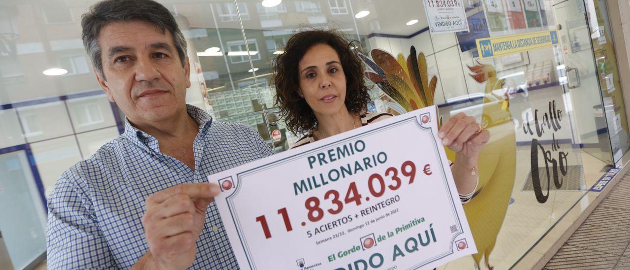 Froilán Blanco y Sandra Rodríguez, con el cartel del premio de 11,8 millones de euros del Gordo de la Primitiva vendido en su administración del Cristo.