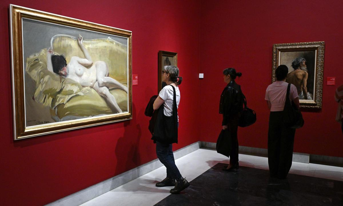 Unos visitantes observan las obras de la exposición.