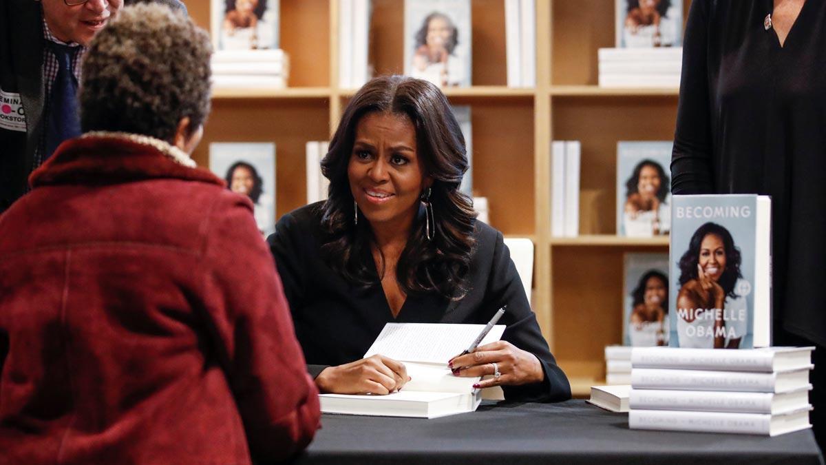 Michelle Obama firma ejemplares de su libro 'Becoming'.