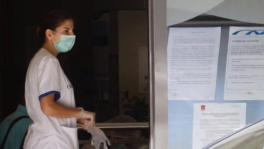 Una mujer con una mascarilla entra en una residencia de mayores en Madrid.