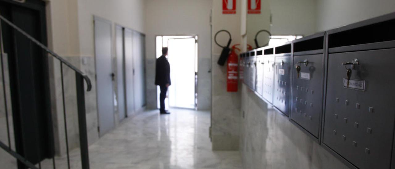 Un hombre a la entrada de un edificio de viviendas.