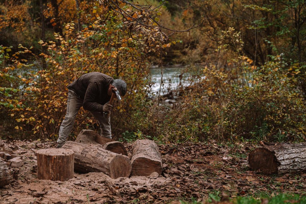 Julio, un vecino que en su tiempo libre se dedica al tallado de jardineras de madera de haya, trabaja a orillas del Eska en el Valle del Roncal.