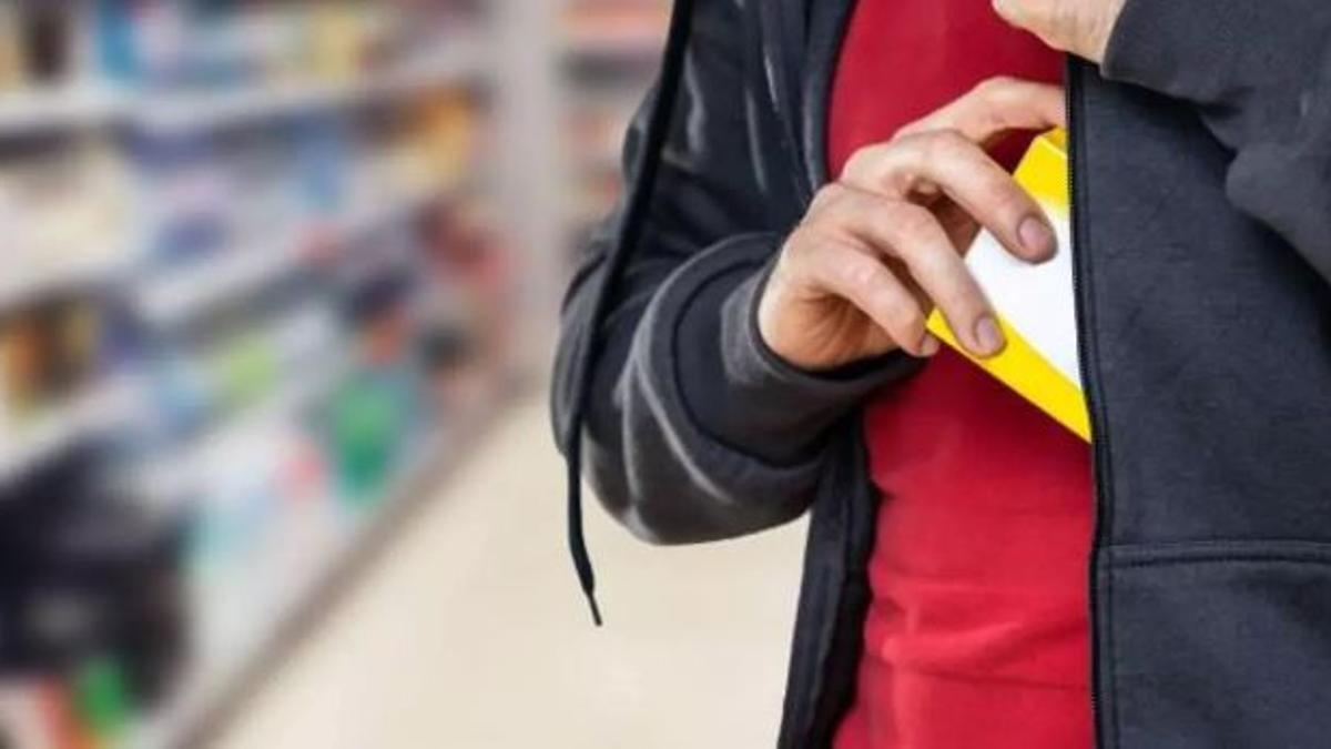 Una persona se introduce un producto dentro de su chaqueta