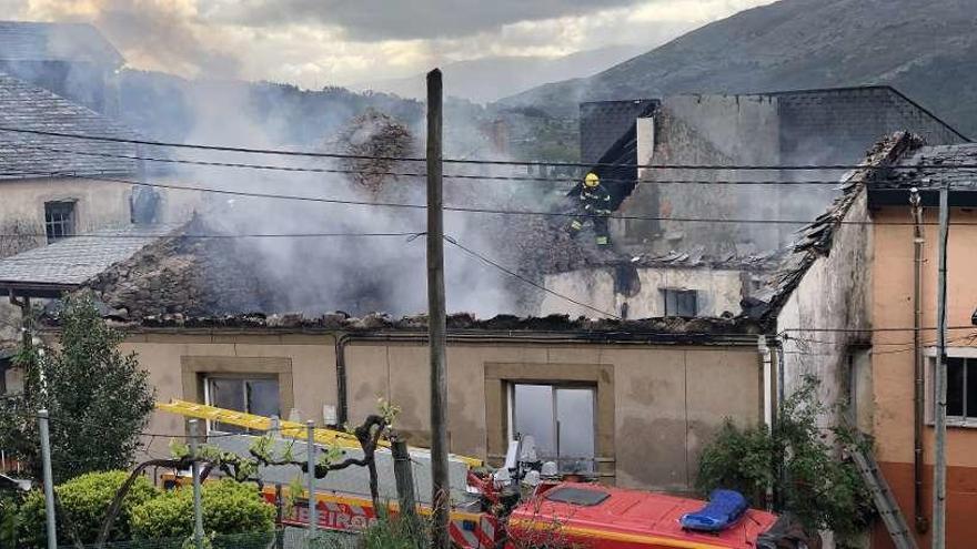 Un bombero trabaja en el tejado de la vivienda afectada, todavía humeante. // Brais Lorenzo