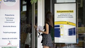 Una joven entra en una oficina de Correos..-EFE/Raquel Manzanares