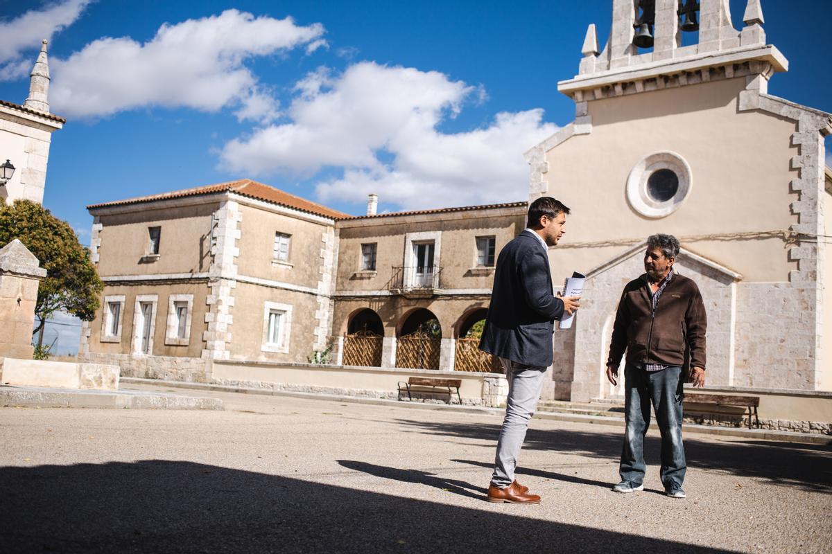 Álvaro Vara departe con un vecino en la plaza de aspecto colonial