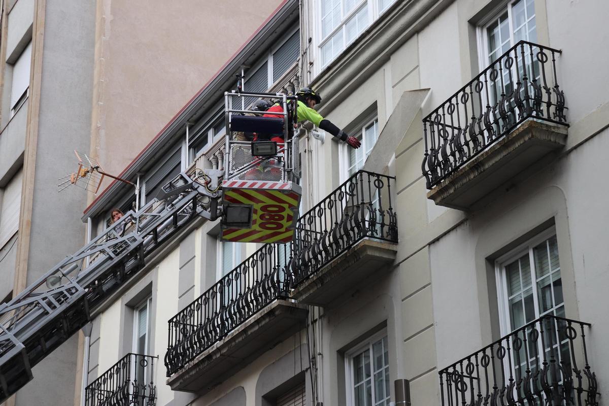 Un bombero retira una placa desprendida de un edificio, en la calle Concordia.