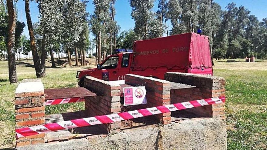 Los bomberos precintan una barbacoa en un paraje natural.