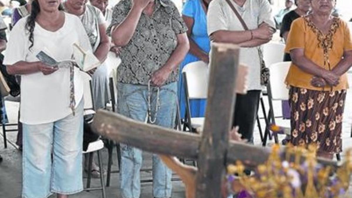 Los padres de los estudiantes asesinados rezan frente a un altar erigido en Ayotzinapa, en memoria de las víctimas de la matanza.