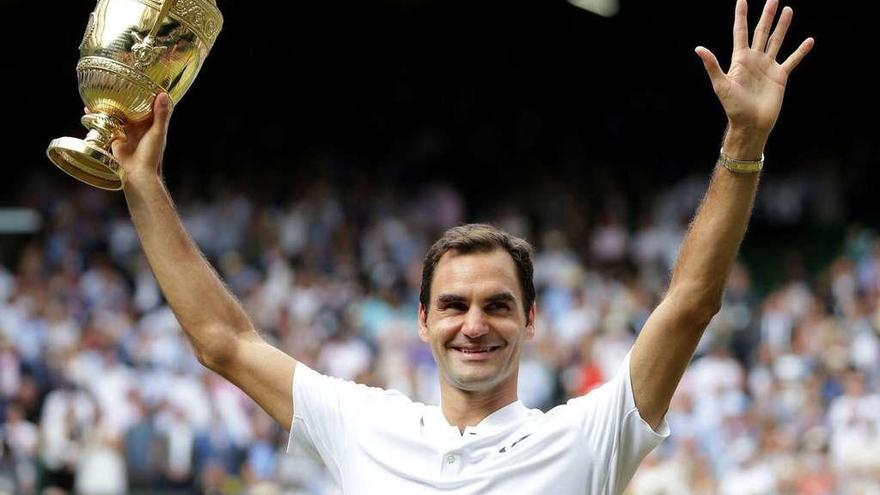 Federer sonríe tras recibir el trofeo que le acredita como campeón de Wimbledon. // Efe