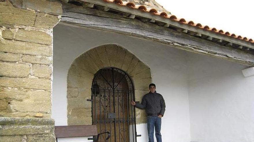 Un joven de Quintanilla de Urz, en la mañana de ayer, muestra el enrejado instalado en las puertas de la ermita.