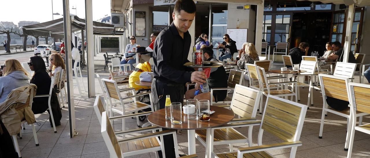 Un camarero recogiendo una mesa de una cafetería, ayer en Sanxenxo