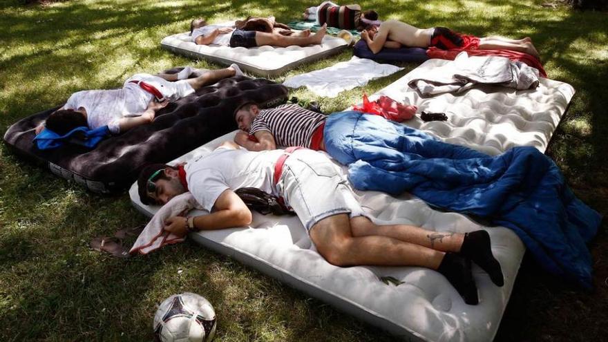 Jóvenes durmiendo al aire libre para reponer fuerzas tras cuatro días de fiesta.