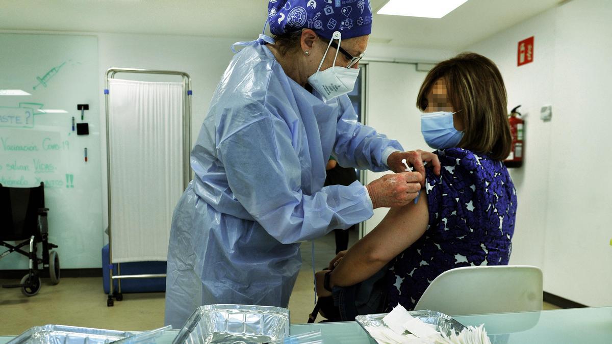 Una mujer recibe una dosis de la vacuna de AstraZeneca en un hospital.