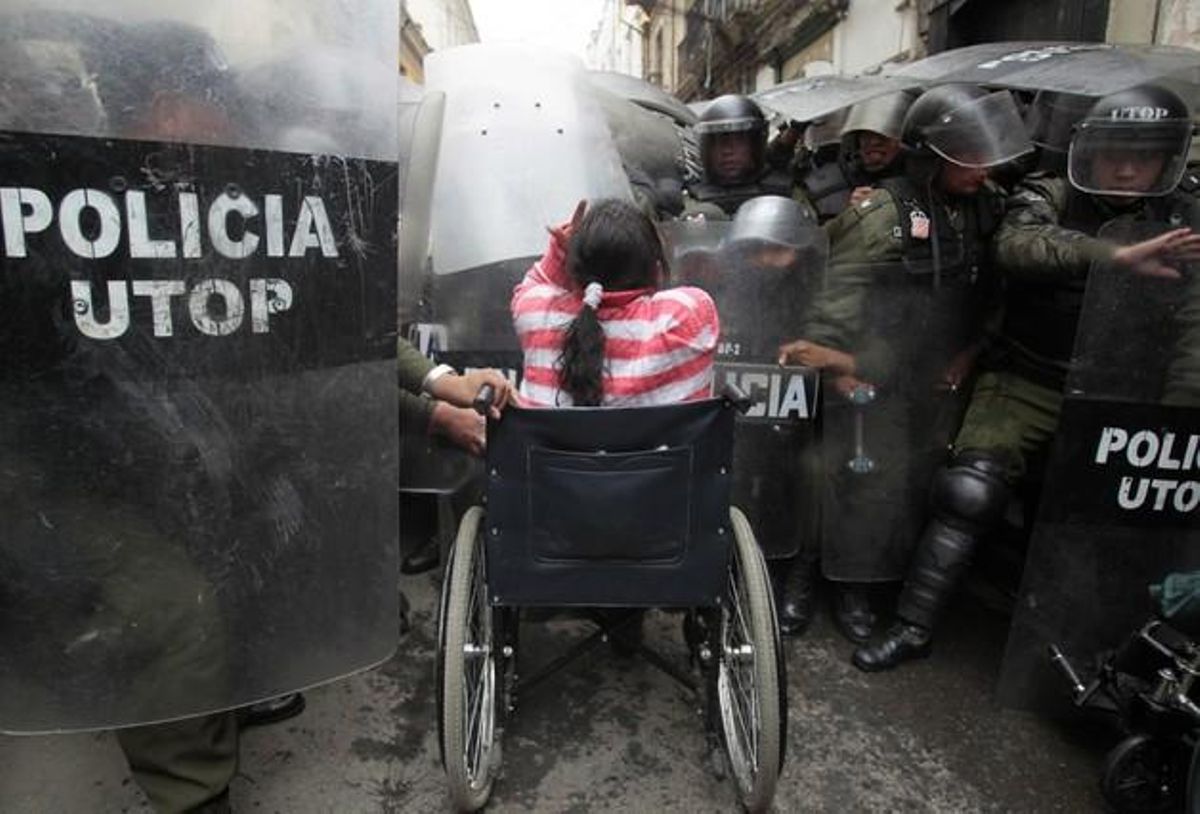 Una mujer en silla de ruedas pelea con la policía en el centro de La Paz.