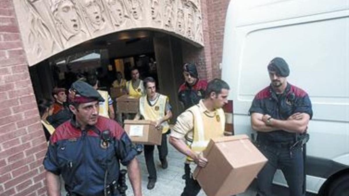 Los mossos cargan en una furgoneta el material incautado en el registro efectuado ayer en el Palau de la Música, propiedad del Orfeó Català.