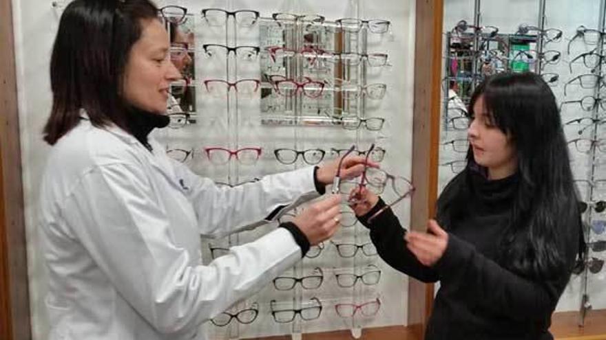 Una joven compra unas gafas en una óptica de La Felguera.