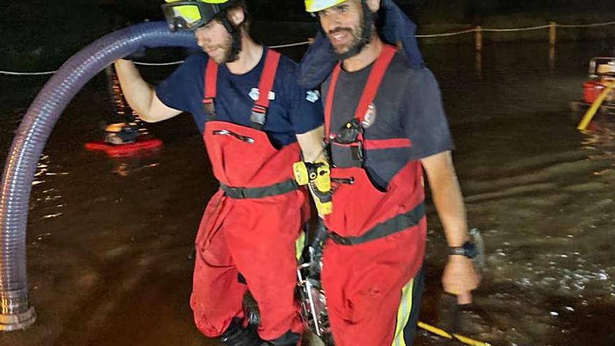 Dos bomberos trasladan una bomba de agua. | CIF