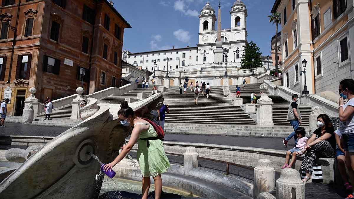 Turistas cogen agua en la fuente de la plaza de España en Roma