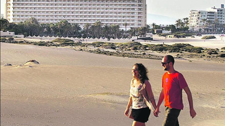 Turistas paseando con el hotel Oliva Beach al fondo.