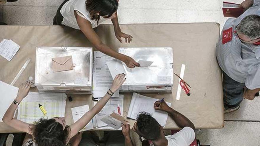 Imagen de unas pasadas elecciones en Balears. En los recuadros, los sobres para votar el 26M.