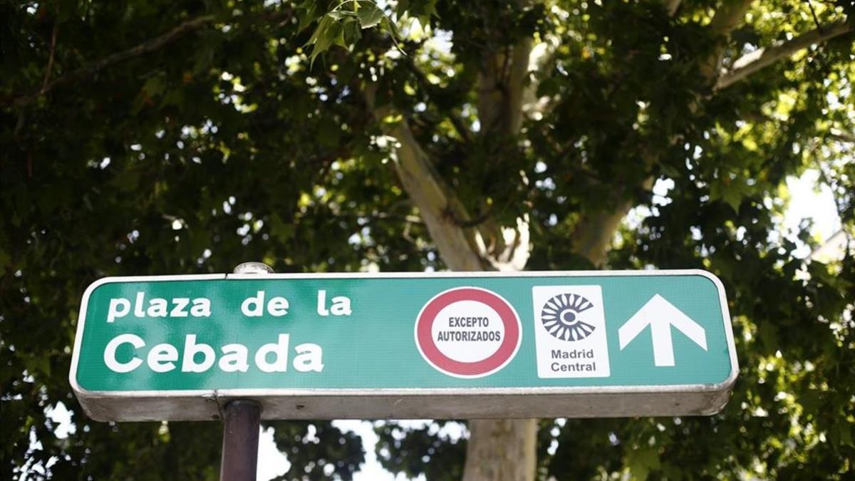 Señal de dirección con un símbolo de prohibido aparcar al lado del distintivo de Madrid