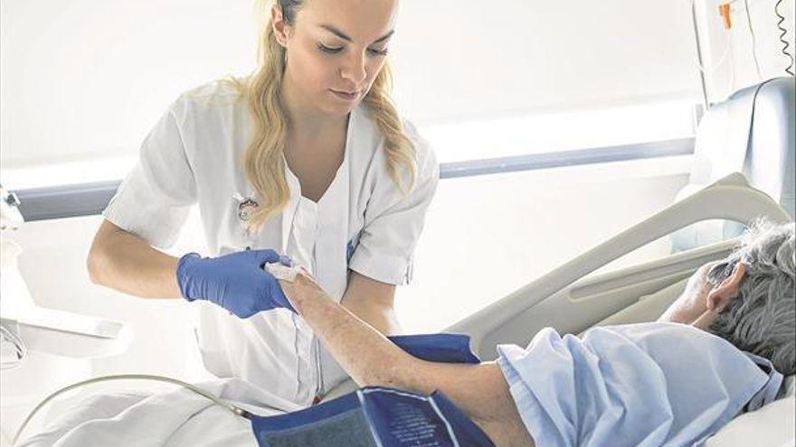 Una sanitaria atiende a un paciente ingresado en un centro hospitalario.