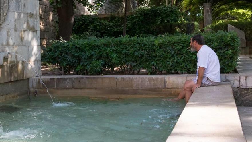 Un hombre se refresca los pies en s´Hort des Rei.