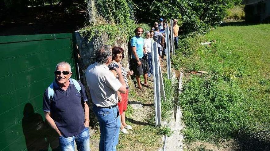 Vecinos supervisando la retirada del cierre. // Gonzalo Núñez