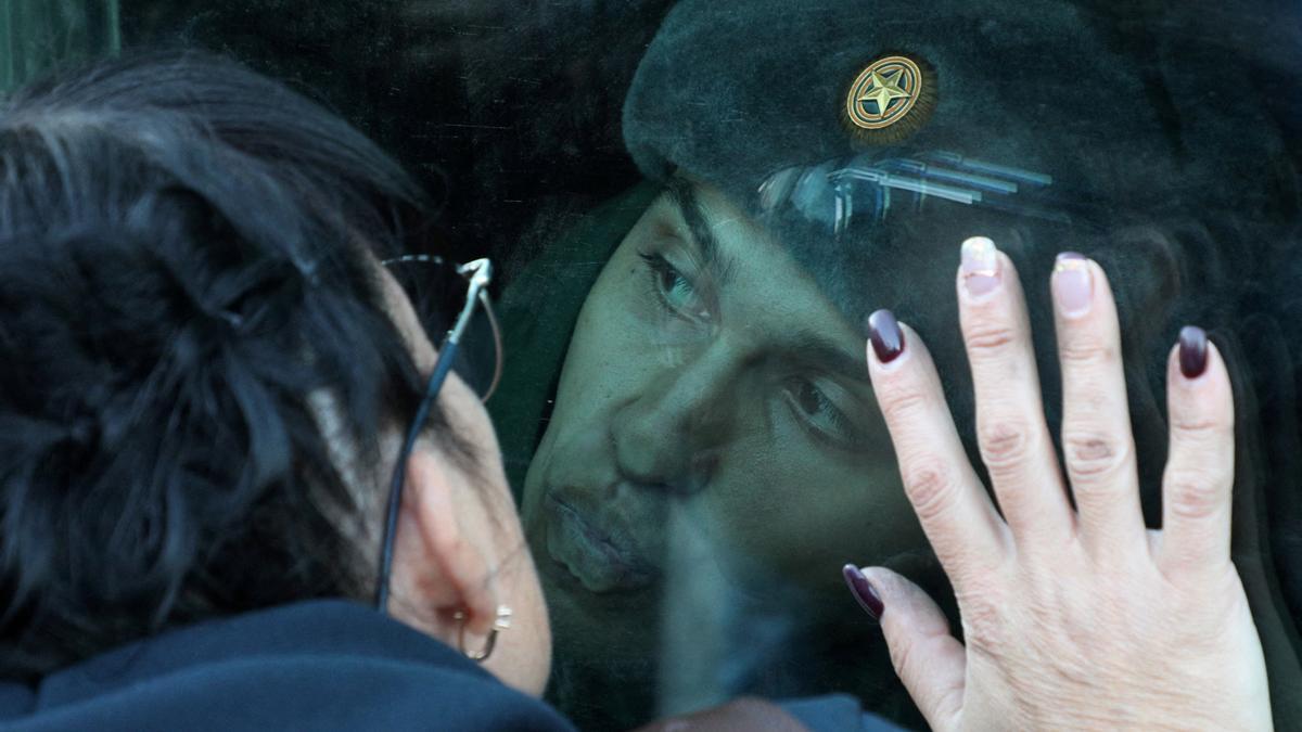 Un recluta besa la ventana de un vagón de tren mientras se despide de sus familiares en una estación de tren local durante la partida hacia las guarniciones, en Sebastopol, Crimea.