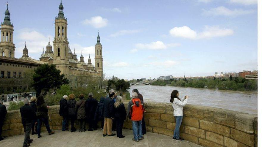 Los zaragozanos se agolpan junto al Ebro para admirar la punta de la crecida