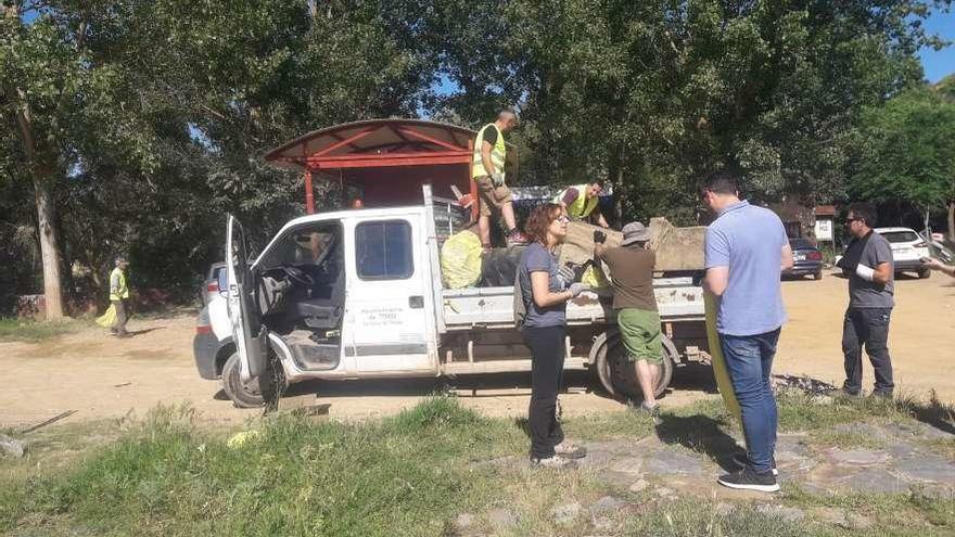 Voluntarios participan en la recogida de basura en la ribera del río.