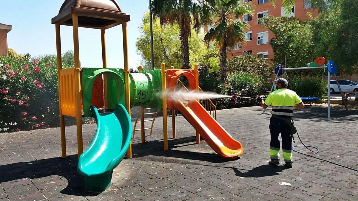 Labores de desinfección de una zona de juegos infantiles de Benetússer. | A.B.