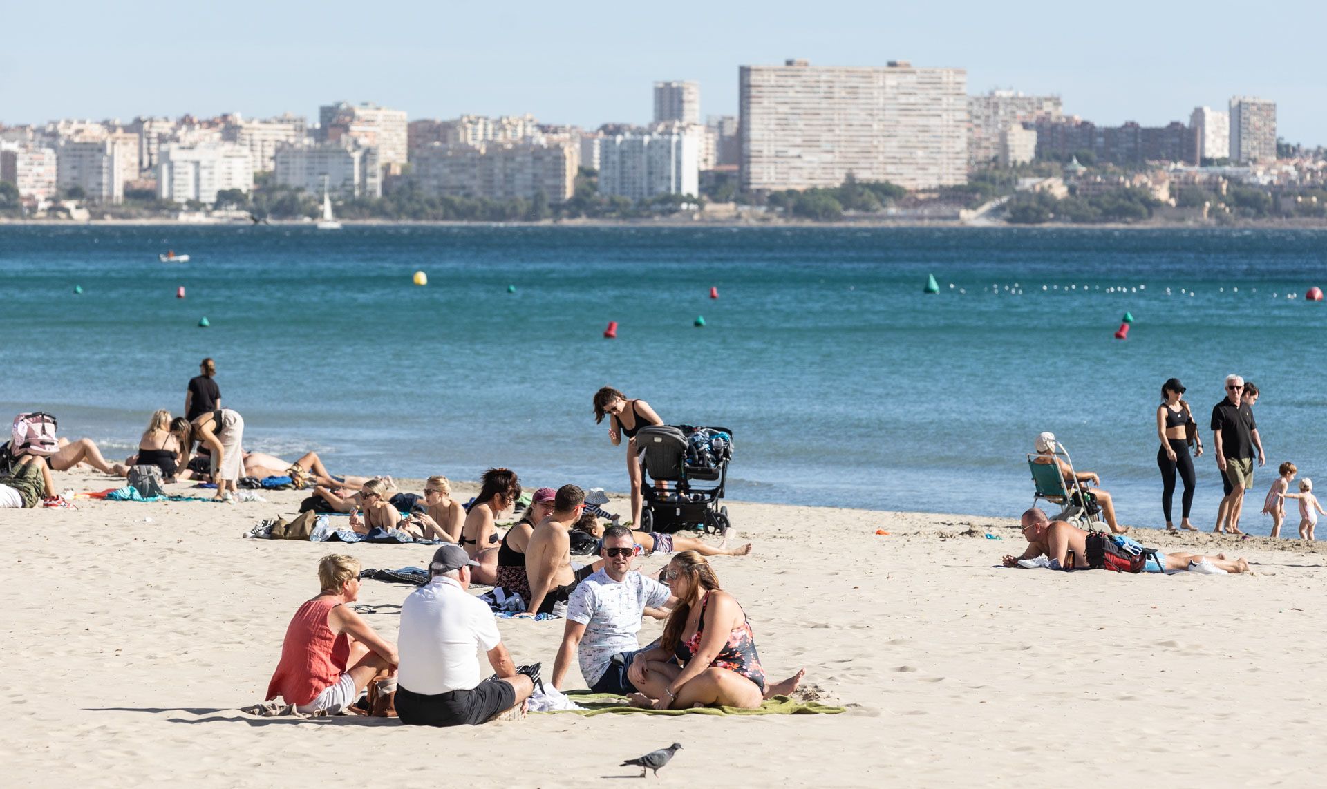 Numerosas personas disfrutan de un primaveral día en la Playa de El Postiguet