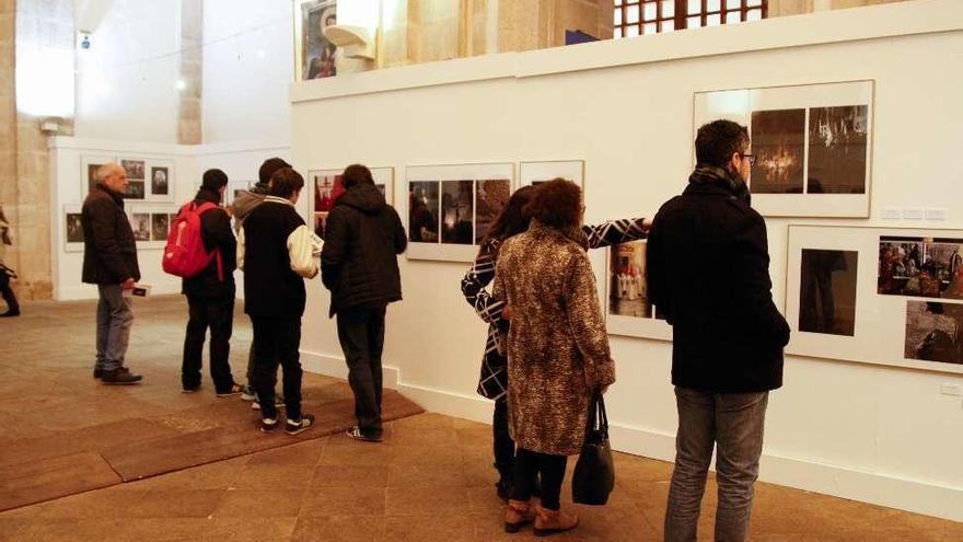 Asistentes a la inauguración observan las imágenes expuestas.