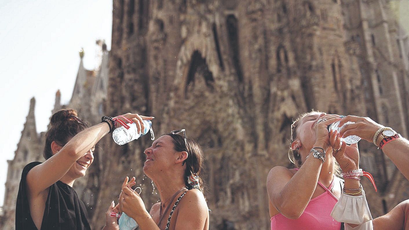 Unas jóvenes se refrescan frente a la Sagrada Família para tratar de superar el calor, el pasado día 11.