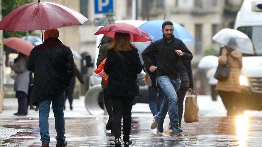Peatones se enfrentan a la lluvia en Pontevedra // Gustavo Santos
