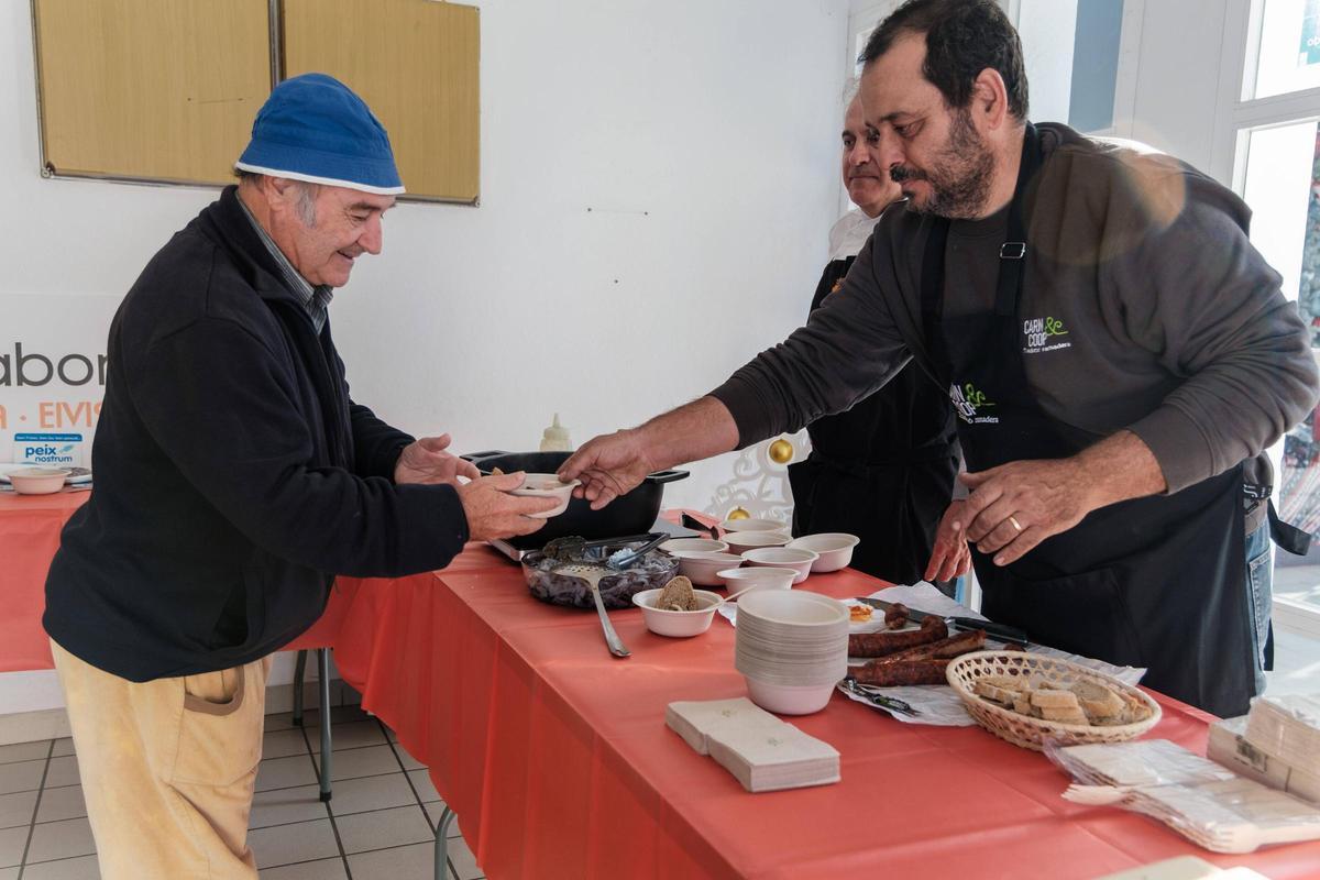 Un visitante del Mercat Nou se anima a probar un plato de calamares con sobrasada