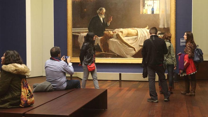 Un grupo de personas contempla el cuadro de Enrique Simonet en Museo de Málaga.