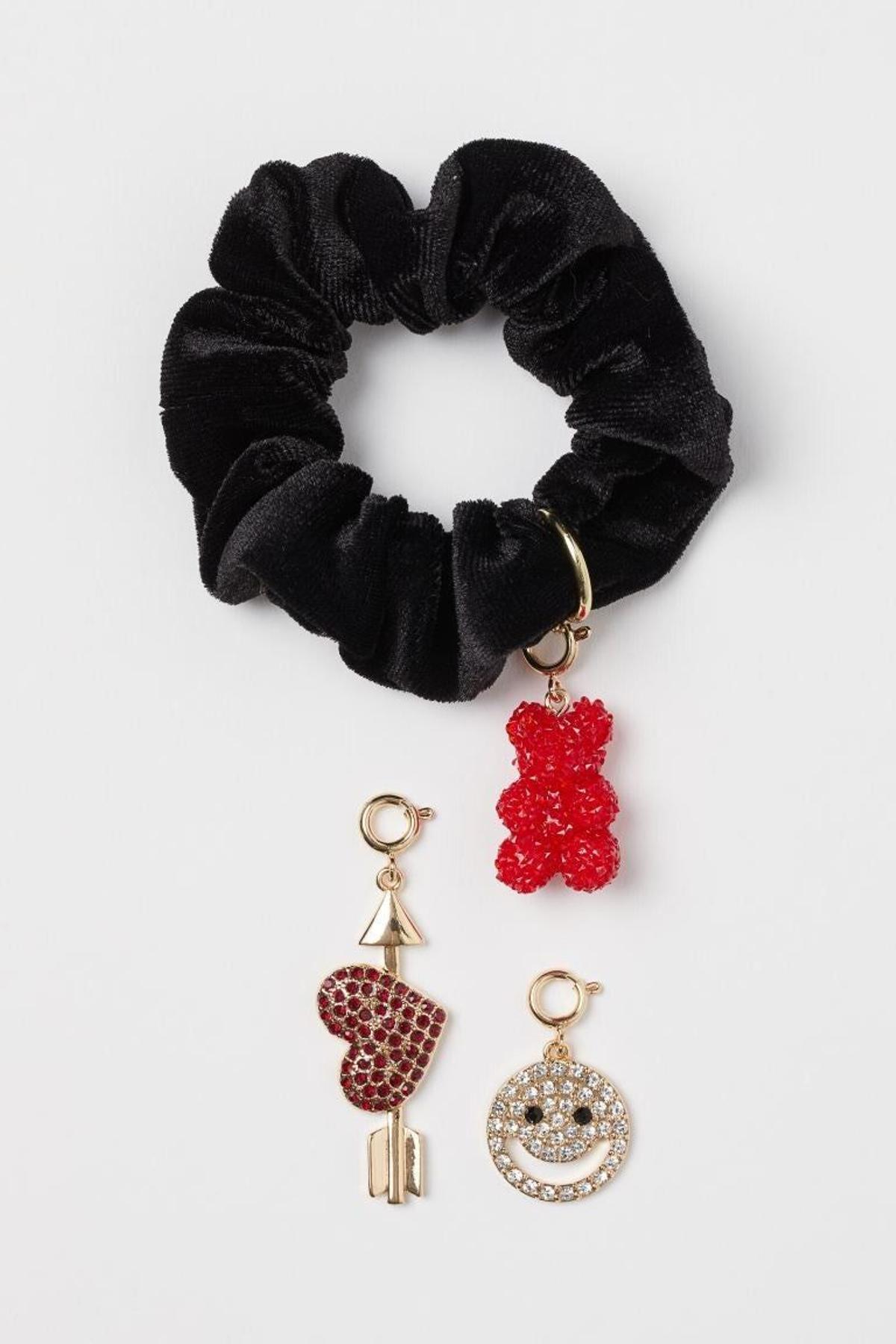 Scrunchie de tercipelo negro con tres charms en forma de corazón, una happy face y un osito de gominola.