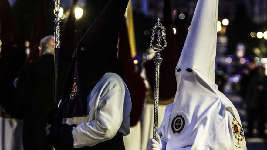 un nazareno de los Estudiantes y otro de la Resurrección de Teatinos, a su paso por las calles de la Tenderina.