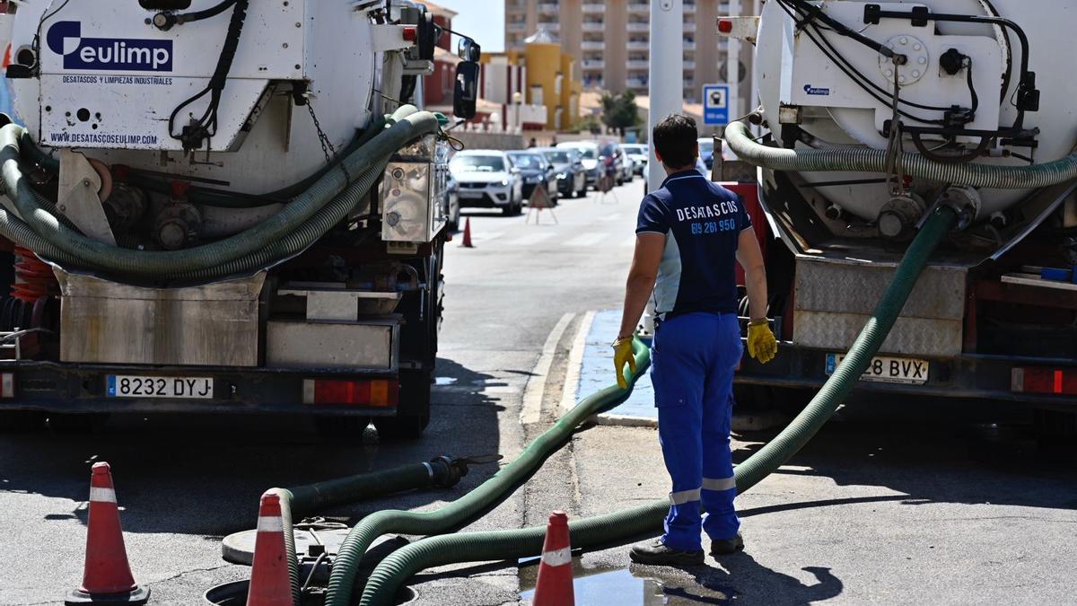 Operarios trabajan en la Gran Vía de La Manga para solucionar el problema del vertido.